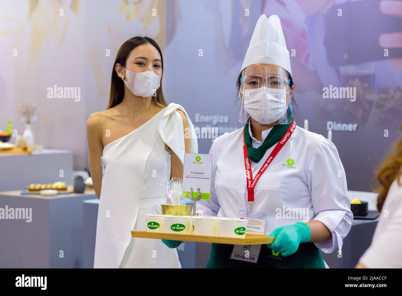 Lebensmittel-Produkte kostenlose Probe fördern Mädchen pritty Frau Modell zum Kunden zu Fuß in Food expo Festival Event Hall.25 Mai 2022.Bangkok, THAILAND. Stockfoto