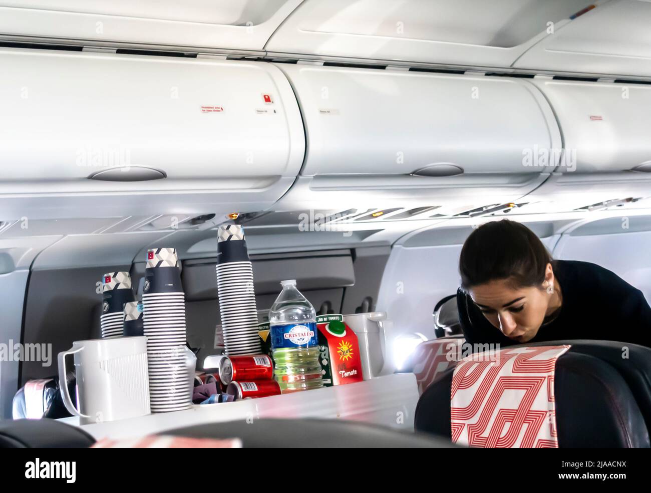 Flugbegleiter, der Passagieren in einer Flugzeugkabine des Typs Airbus A319 von Air France Mahlzeiten und Getränke serviert Stockfoto