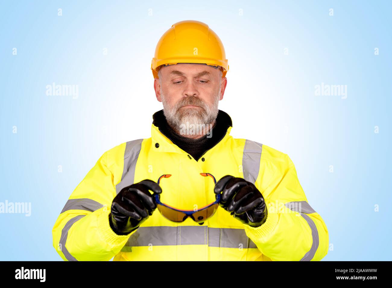 Bauarbeiter mit gelber weste steht vor dem see. arbeiter mit gelbem helm