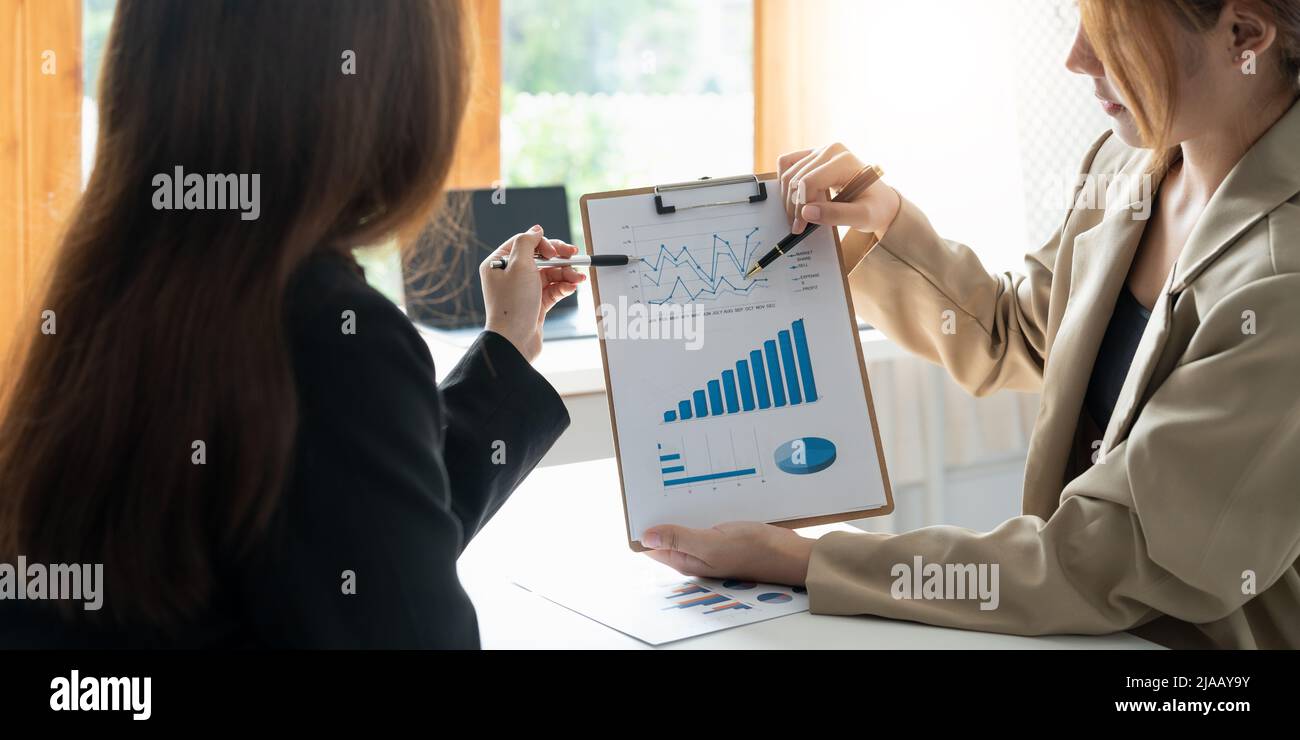 Führungskräfte und Buchhalter halten die Jahresabschlüsse des Unternehmens und diskutieren sie gemeinsam, Buchhalter diskutieren die Finanzgespräche des Unternehmens Stockfoto