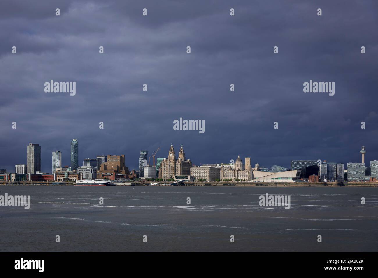 Die Skyline von Liverpool am Wasser bei dunklem Himmel. Stockfoto