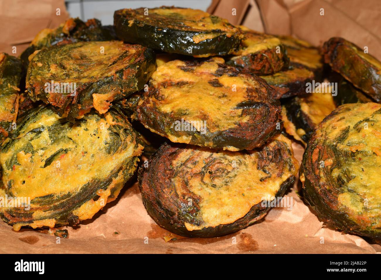 Saheena, die in Trinidad, Westindien, hergestellt wird. Saheena wird aus Dasheen-Busch-Bhagi oder Spinat hergestellt, in gespaltenen Erbsen-Pulver zerschlagen und frittiert. Stockfoto