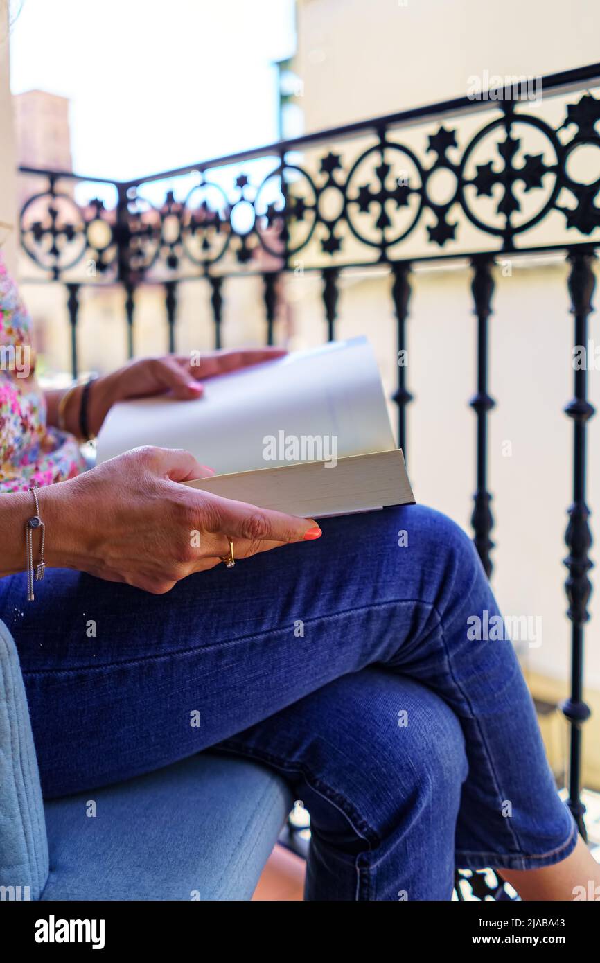 Frau mit einem Buch auf dem Balkon ihres Hauses, Spanien, Europa, zu lesen. Stockfoto