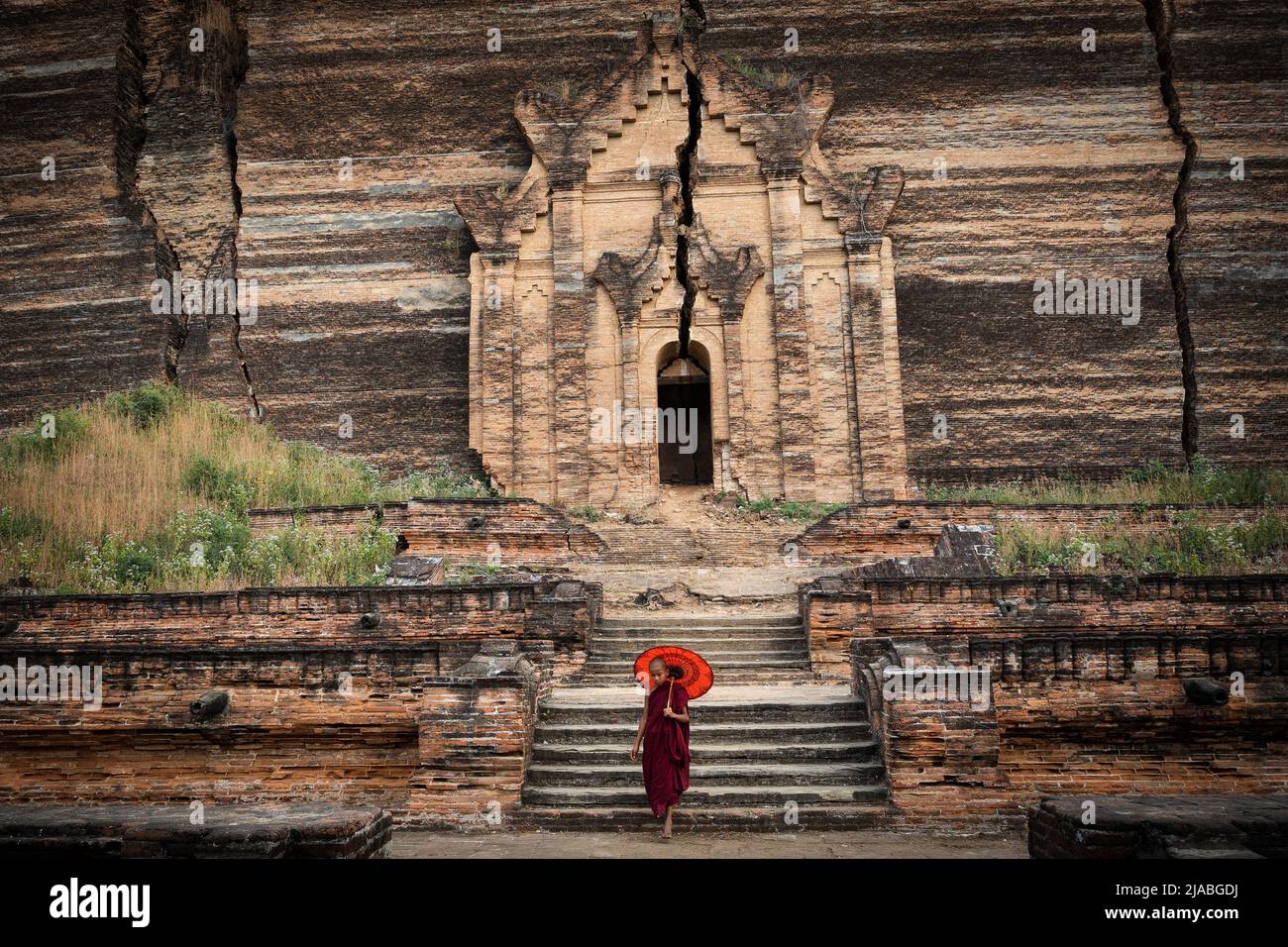 Ein buddhistischer Novize besucht die Ruinen der Mingun Pahtodawgyi Pagode in Sagaing, Mandalay, Myanmar (Burma). Stockfoto