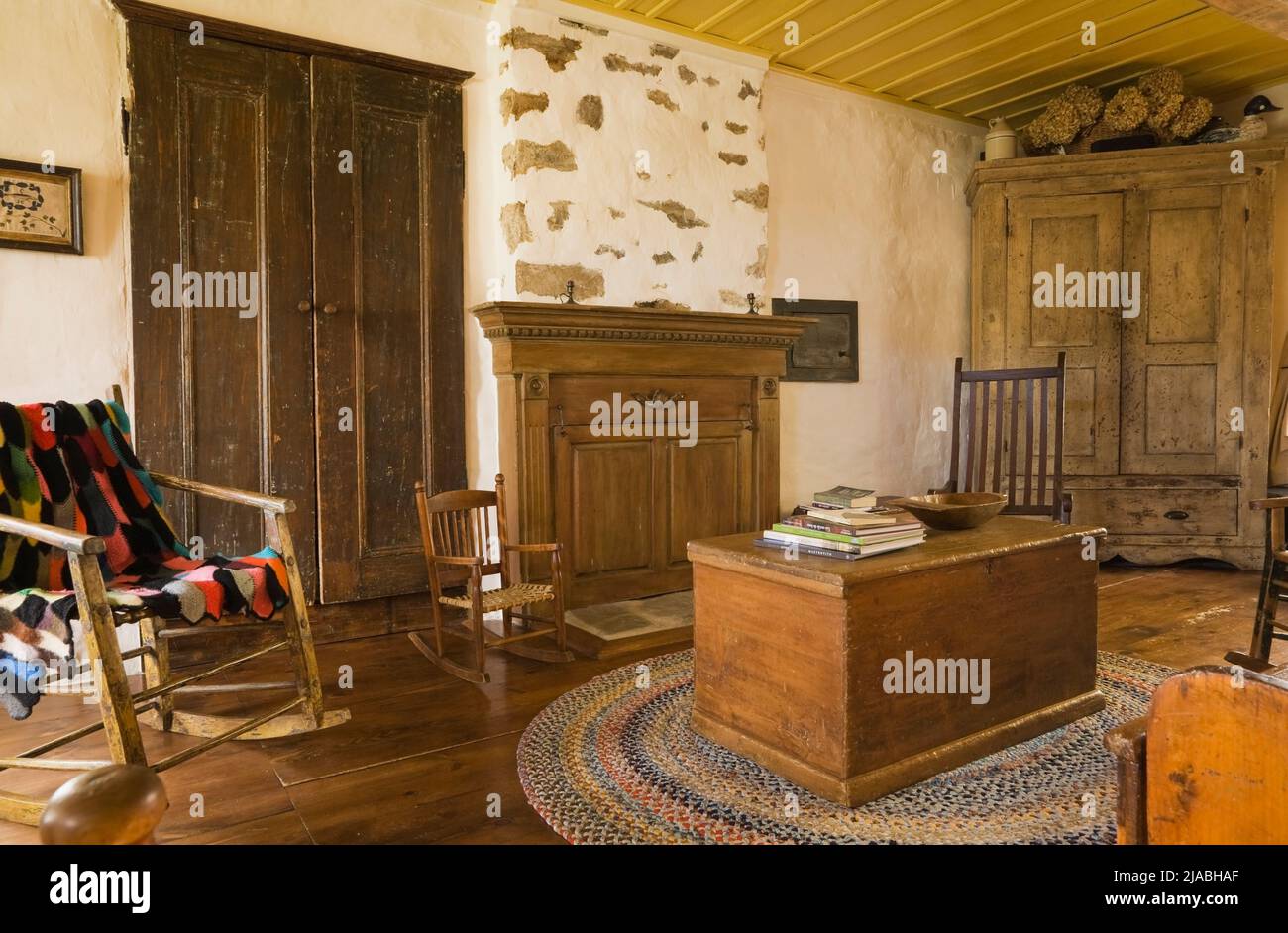 Antike Truhen, Schaukelstühle, Schrank und Möbel im Wohnzimmer im alten, um 1840 im kanadischen Landhausstil gehaltenen Feldsteinhaus. Stockfoto