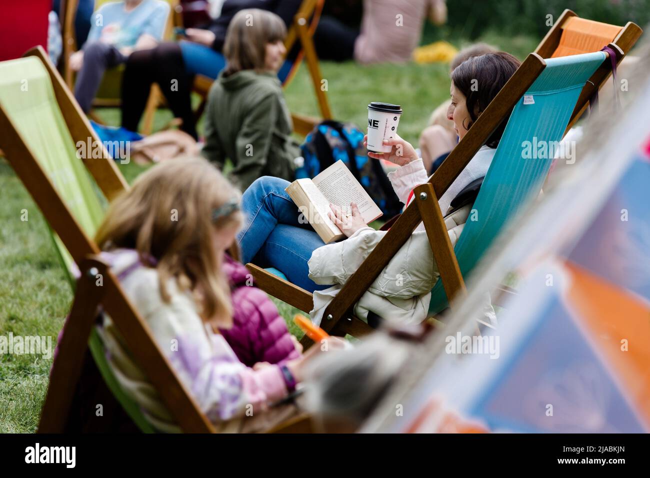 Am 4. Tag des Hay Festivals lesen die Menschen gerne auf dem Rasen. Stockfoto