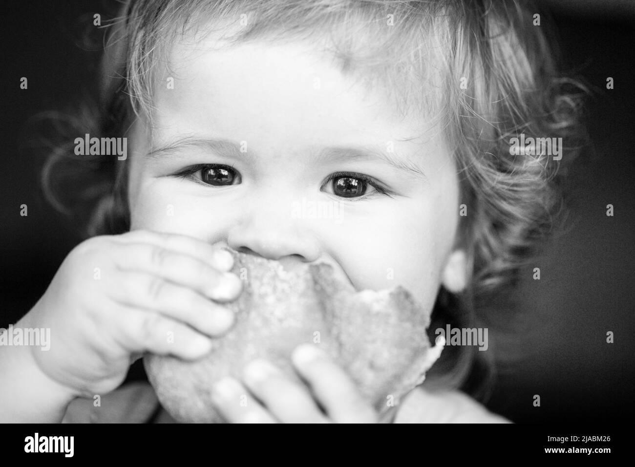 Baby essen Brötchen Brot. Nahaufnahme. Nettes Kleinkind Kind essen Sandwich, Selbstfütterung Konzept. Stockfoto