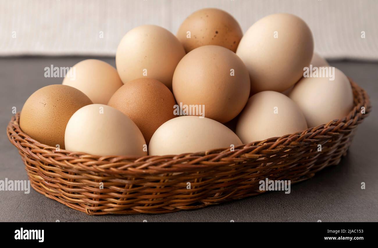 Hühnereier auf dem Bauernhof. Viele Eier in einem Korbkorb aus der Nähe. Stockfoto