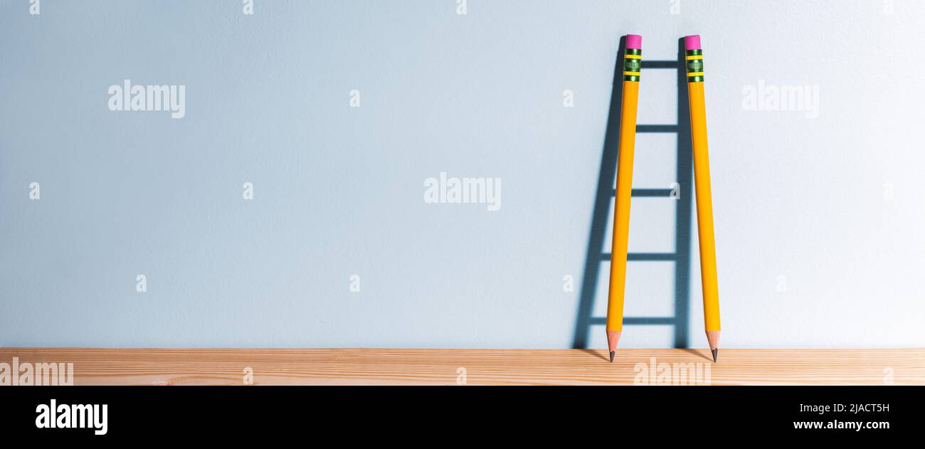 Zwei Bleistifte Auf Dem Schreibtisch Casting Shadow Of Ladder - Erfolg Durch Bildungskonzept Stockfoto