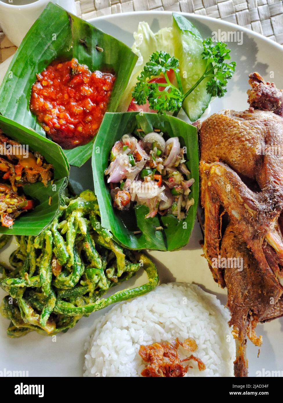 Blick von oben auf knusprige Ente mit Reis, Chilisauce und Gemüse Stockfoto