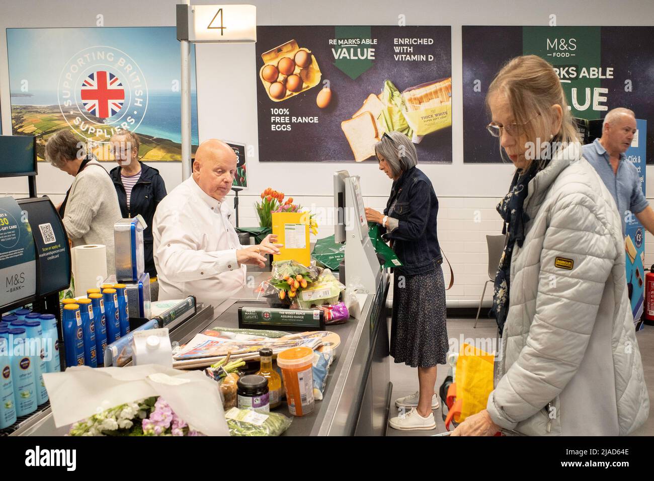 Ein überfüllter Supermarkt Check-out mit Kunden Verpackung und Zahlung für ihre Einkäufe Stockfoto