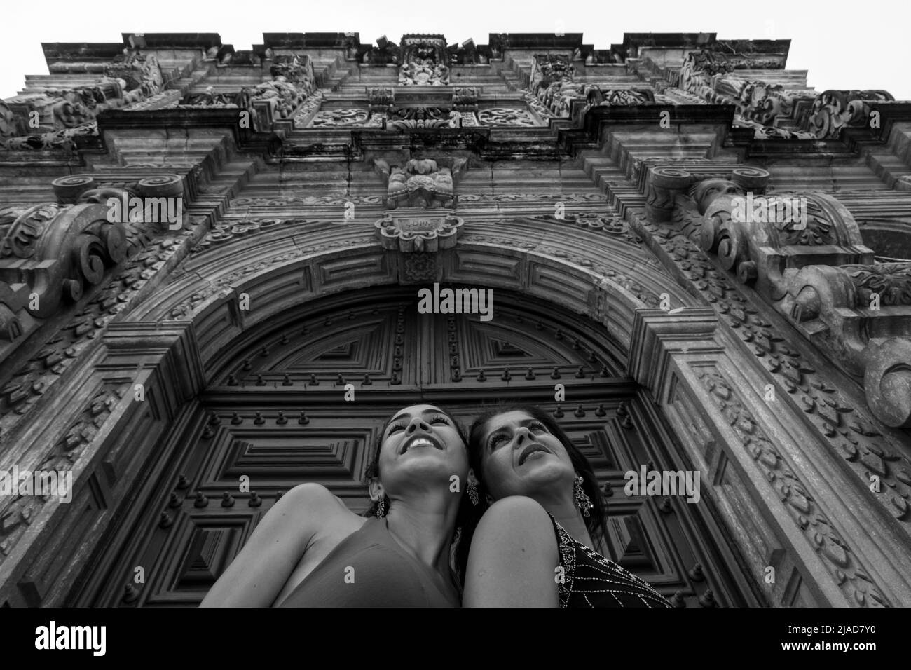 Portrait von zwei Frauen, die die Karnevalsmaske von Venedig an einer Kirchenwand tragen. Pelourinhous, Stadt Salvador, Bahia, Brasilien. Stockfoto