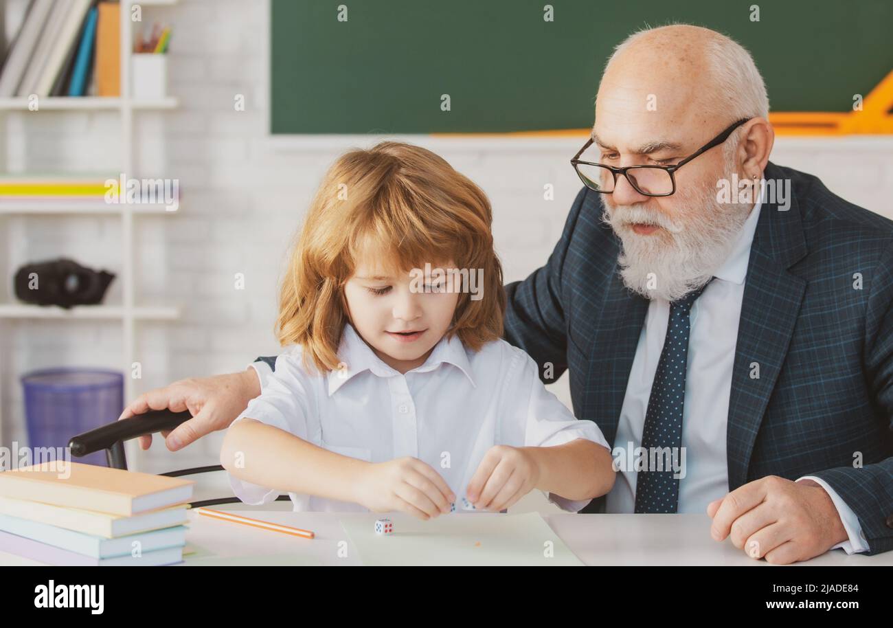 Oberlehrer oder Großvater und Schüler im Klassenzimmer der Schule. Privatunterricht. Alte Tutor Lehrer helfen kleinen Jungen Schüler mit dem Studium der Mathematik Stockfoto