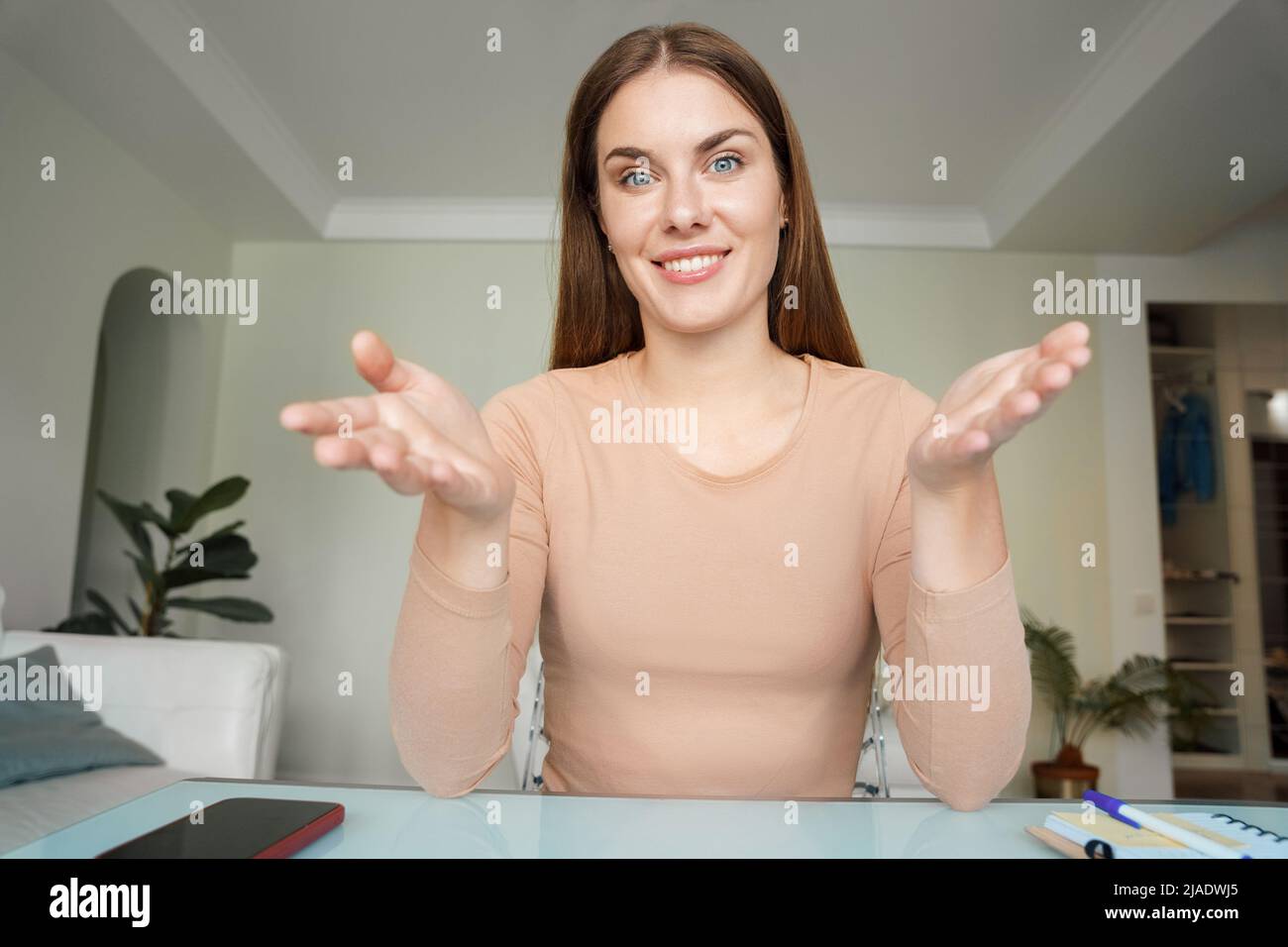 Webcam-Ansicht einer Frau, die mit der Kamera spricht und am Tisch sitzt Stockfoto