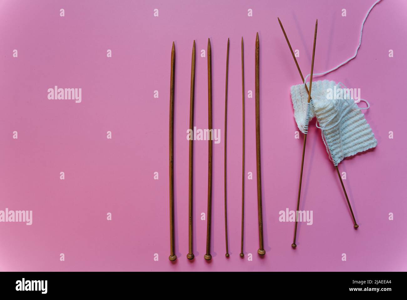 stricknadeln auf rosa Hintergrund Stockfoto