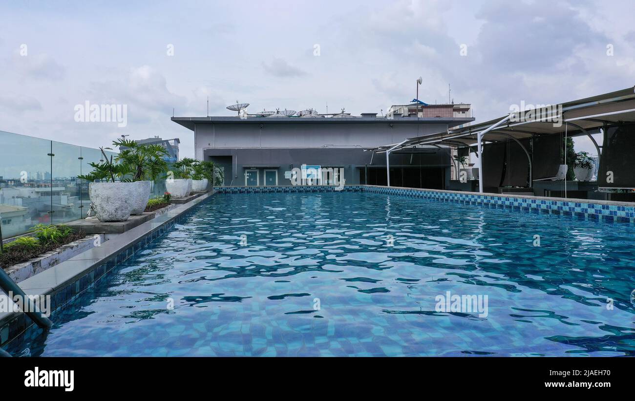 Luxuriöser Pool auf dem Dach bei Sonnenuntergang, verschwommene Bewegung Stockfoto