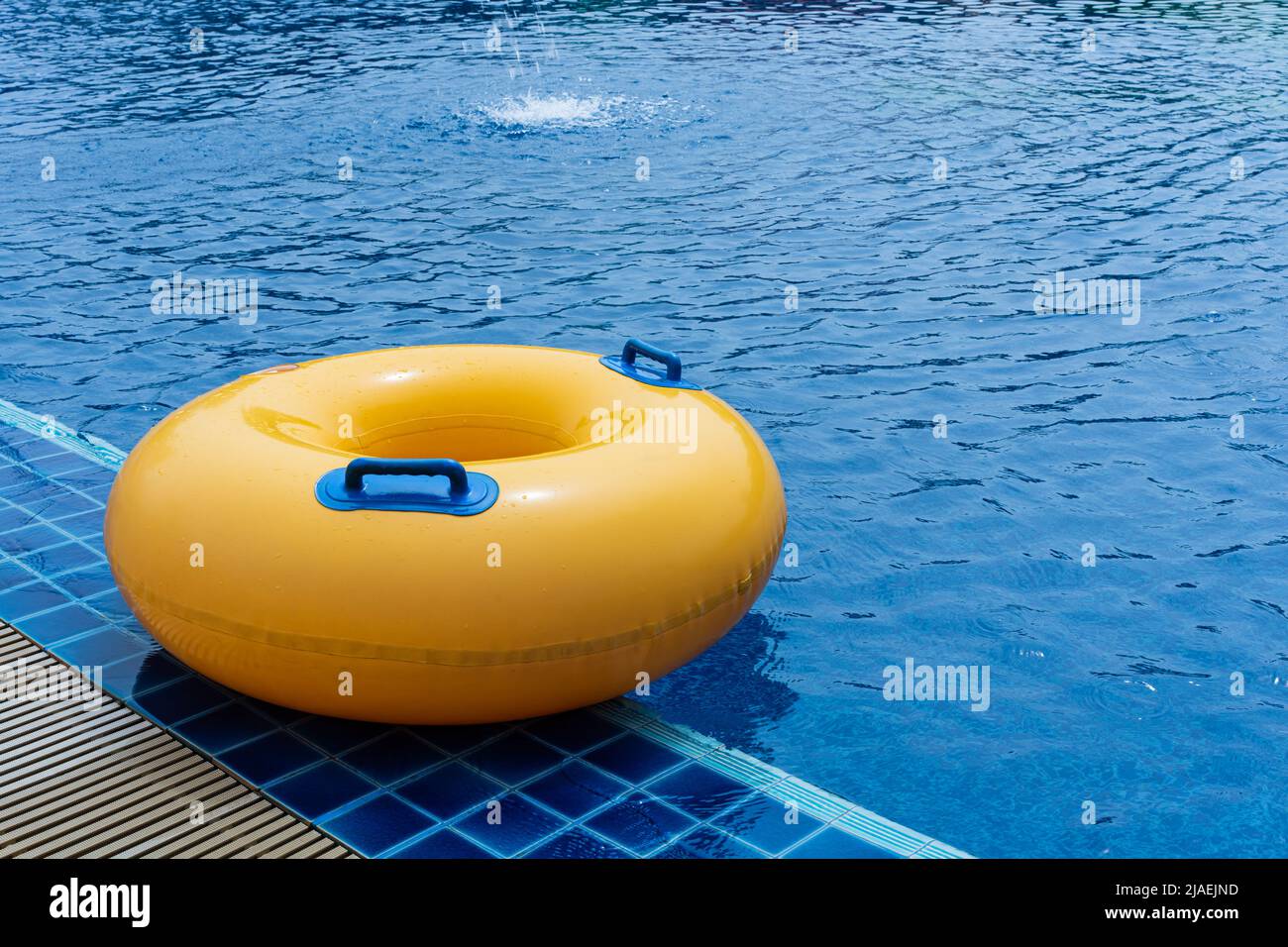 Gelber Schwimmring im Schwimmbad. Gummiring schwimmend. Sommerkonzept. Stockfoto