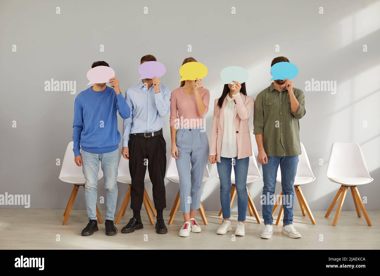 Eine Gruppe von Menschen, die ihre Gesichter hinter Sprechblasen verstecken und ihre Meinungen anonym teilen Stockfoto