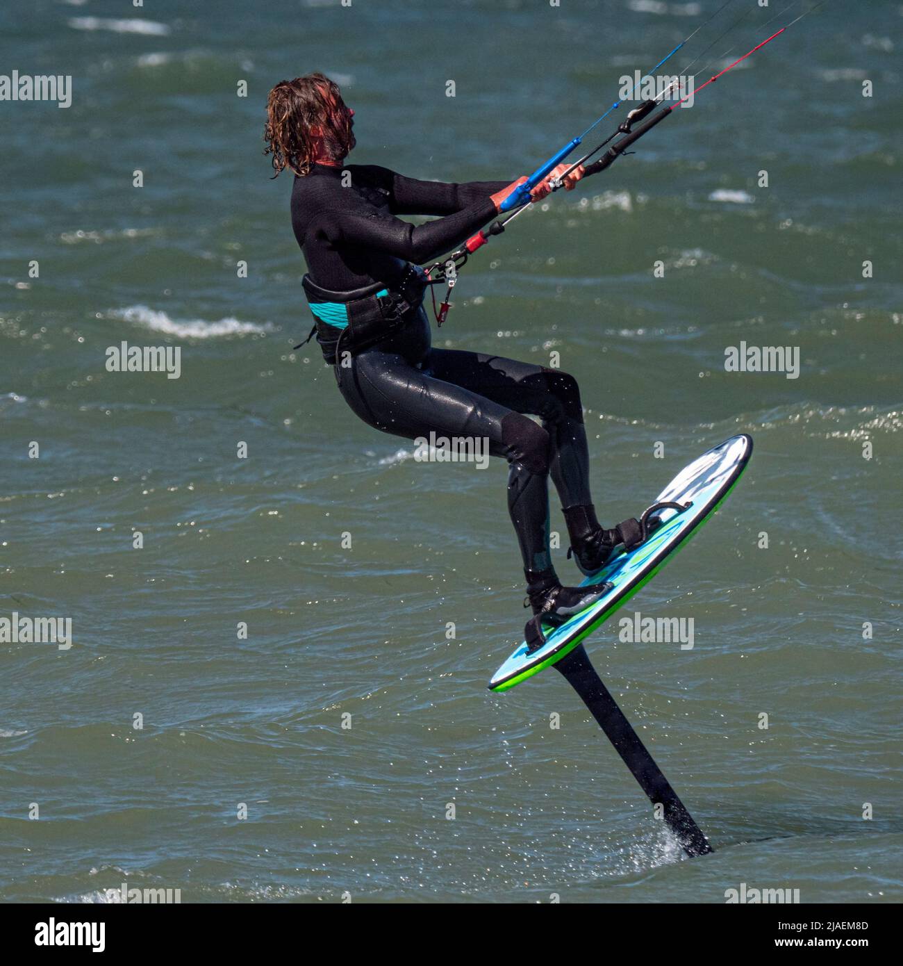 Kitesurfer mit Bart und langen Haaren auf dem Meer. Nahaufnahme Stockfoto