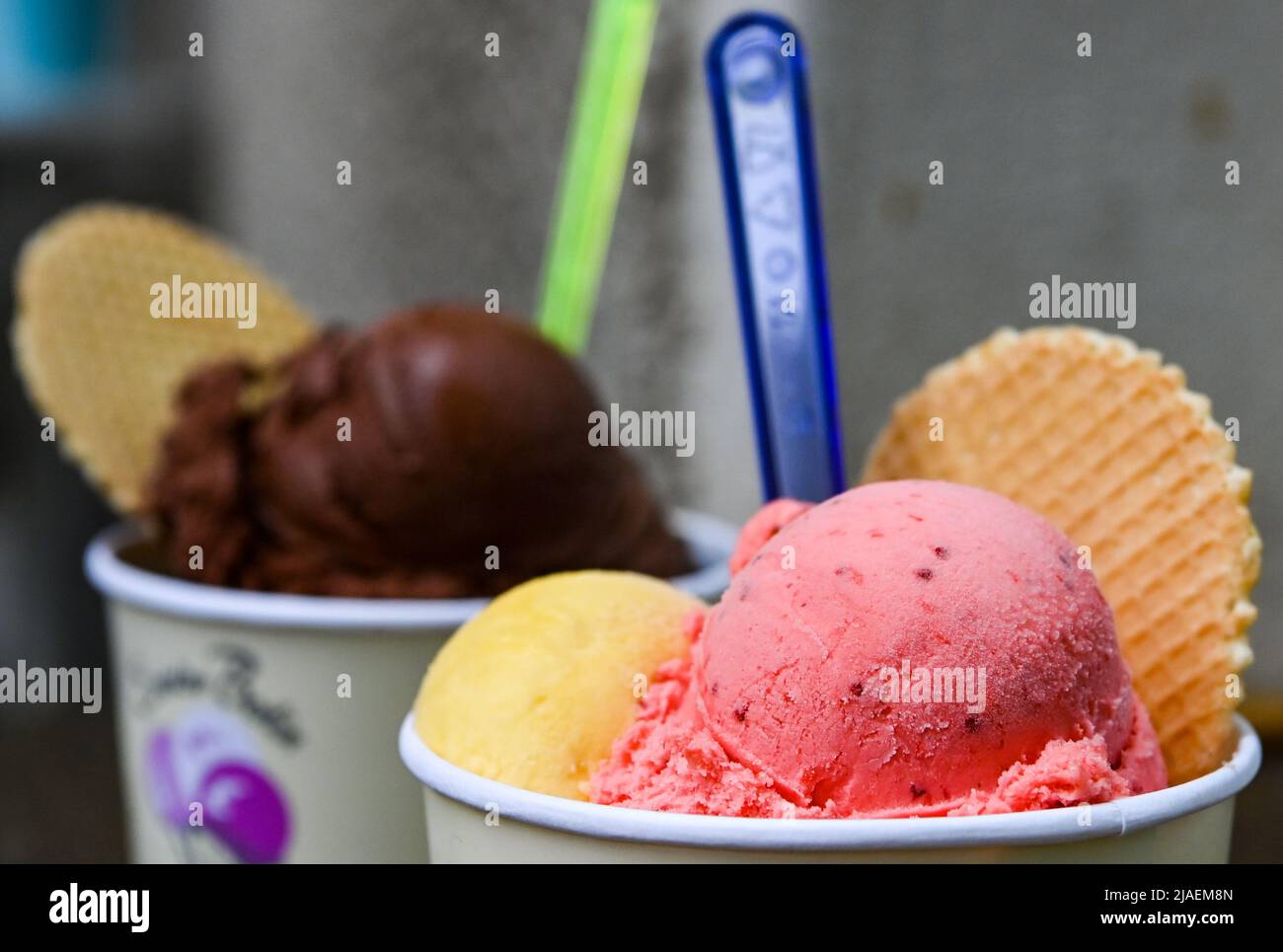 Berlin, Deutschland. 24.. Mai 2022. Eisbecher mit Schaufeln verschiedener Eisarten stehen auf einem Tisch in der Eiskultur-Eisdiele in Schöneweide. Eis und Sorbet gehören für viele Deutsche zum Sommer. Jedes Jahr werden neue Geschmacksrichtungen zum Trend erklärt. Viele bevorzugen jedoch die klassischen Aromen von Vanille, Schokolade und Erdbeere. (To dpa: „Sommertrends 22: Fischhüte in, Booties out?“) Quelle: Jens Kalaene/dpa/Alamy Live News Stockfoto