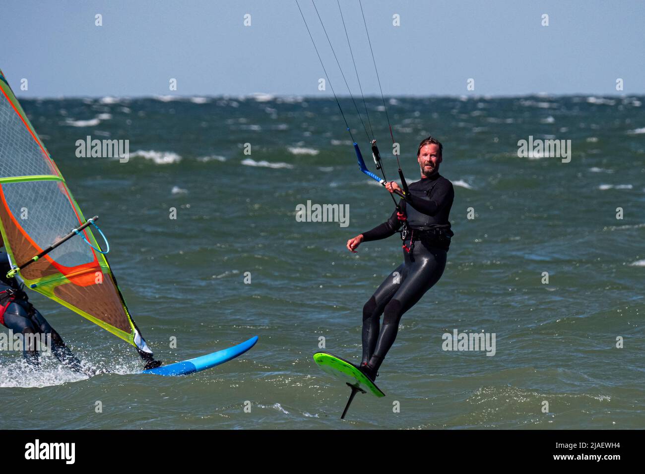 Männlicher Kitesurfer und Windsurfer auf dem Meer. Nahaufnahme Stockfoto