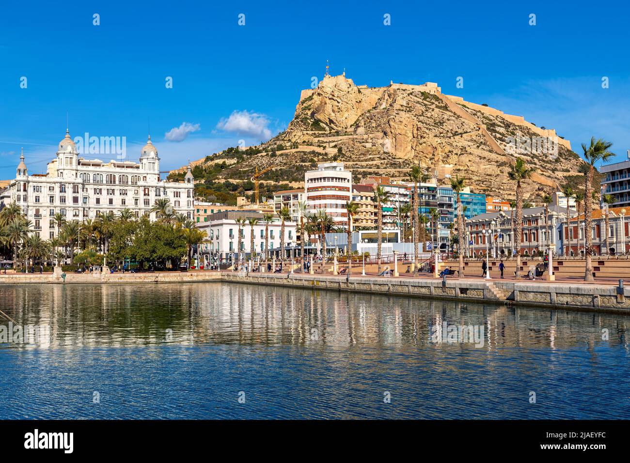 Promenade mit Palmen und Gebäuden im Hintergrund und Mount Benacantil vom Yachthafen in Alicante, Spanien aus gesehen. Stockfoto