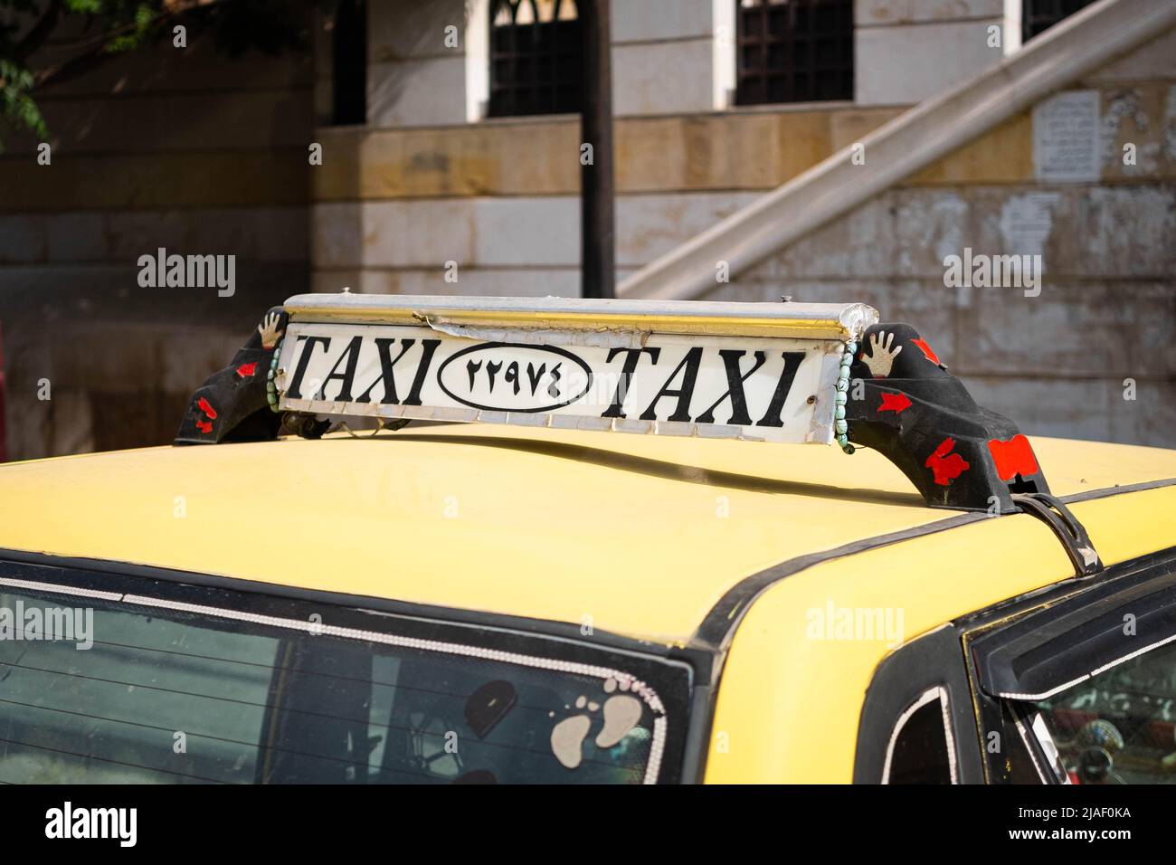 Damaskus, Syrien - Mai, 2022: Taxi-Schild in Nahaufnahme auf Taxi-Auto im Straßenverkehr von Damaskus Stockfoto