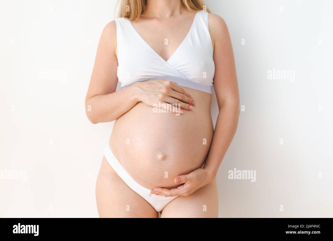 studioaufnahme eines Schwangeren Bauches auf weißem Hintergrund Stockfoto