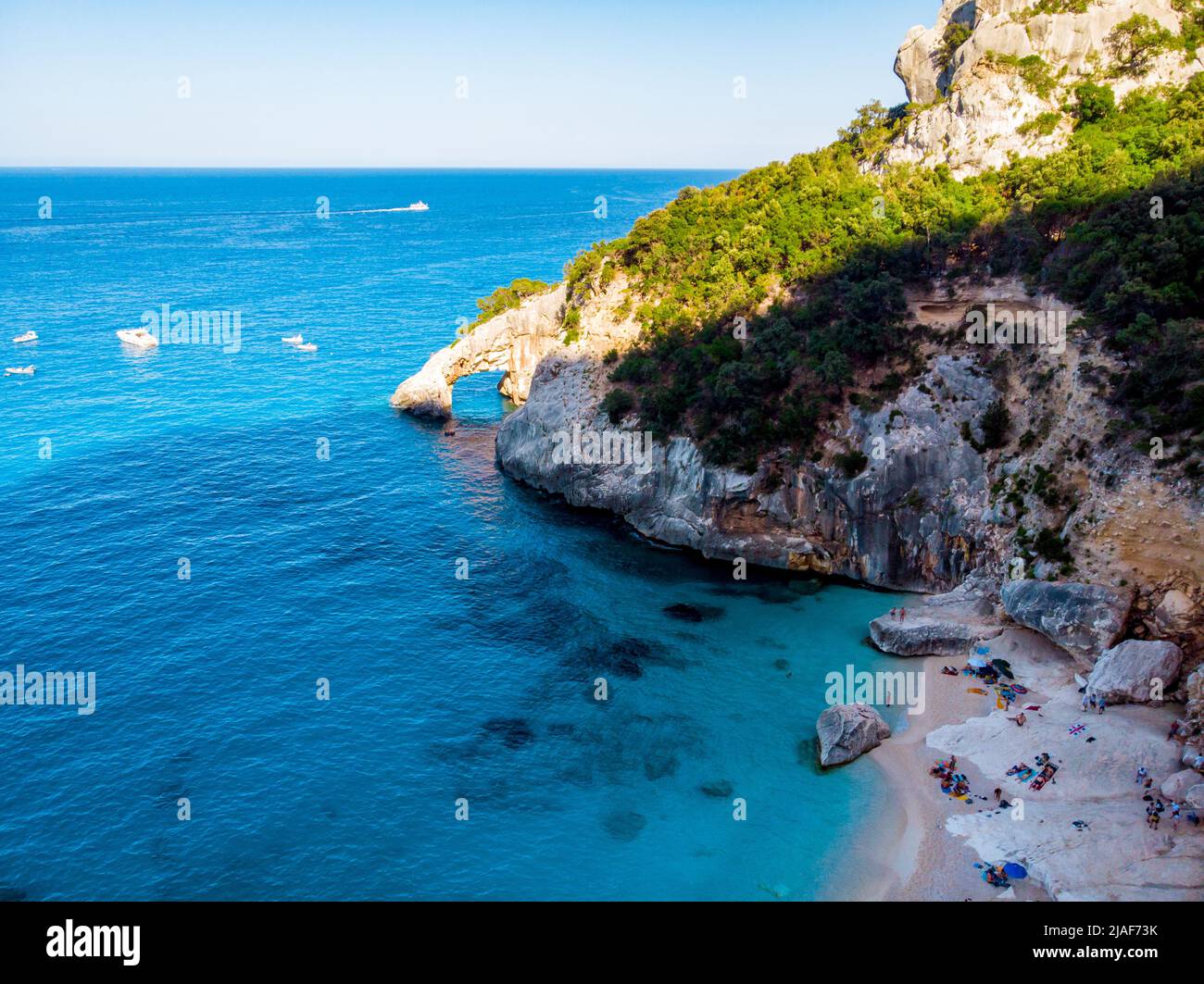 Golfo di Orosei Sardina, Blick von oben, atemberaubende Luftaufnahme eines Strandes voller Sonnenschirme und Menschen, die auf türkisfarbenem Wasser sonnenbaden und schwimmen. Cala Gonone, Sardinien, Italien, Cala Mariolu. Stockfoto