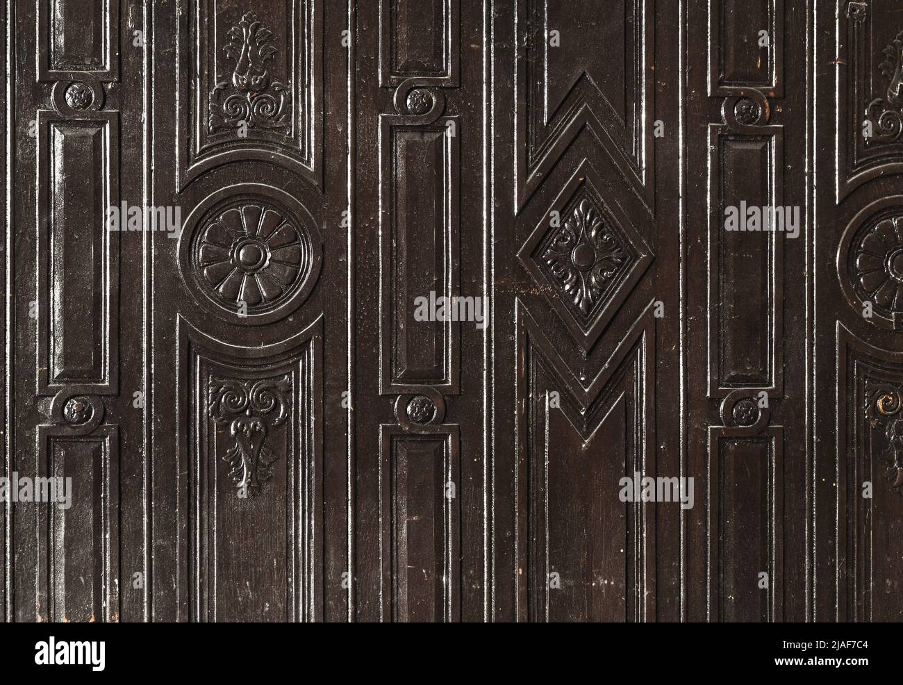 Wandpaneel aus dunklem Moor-Eichenholz mit dekorativem Schnitzmuster, Hintergrundstruktur Stockfoto