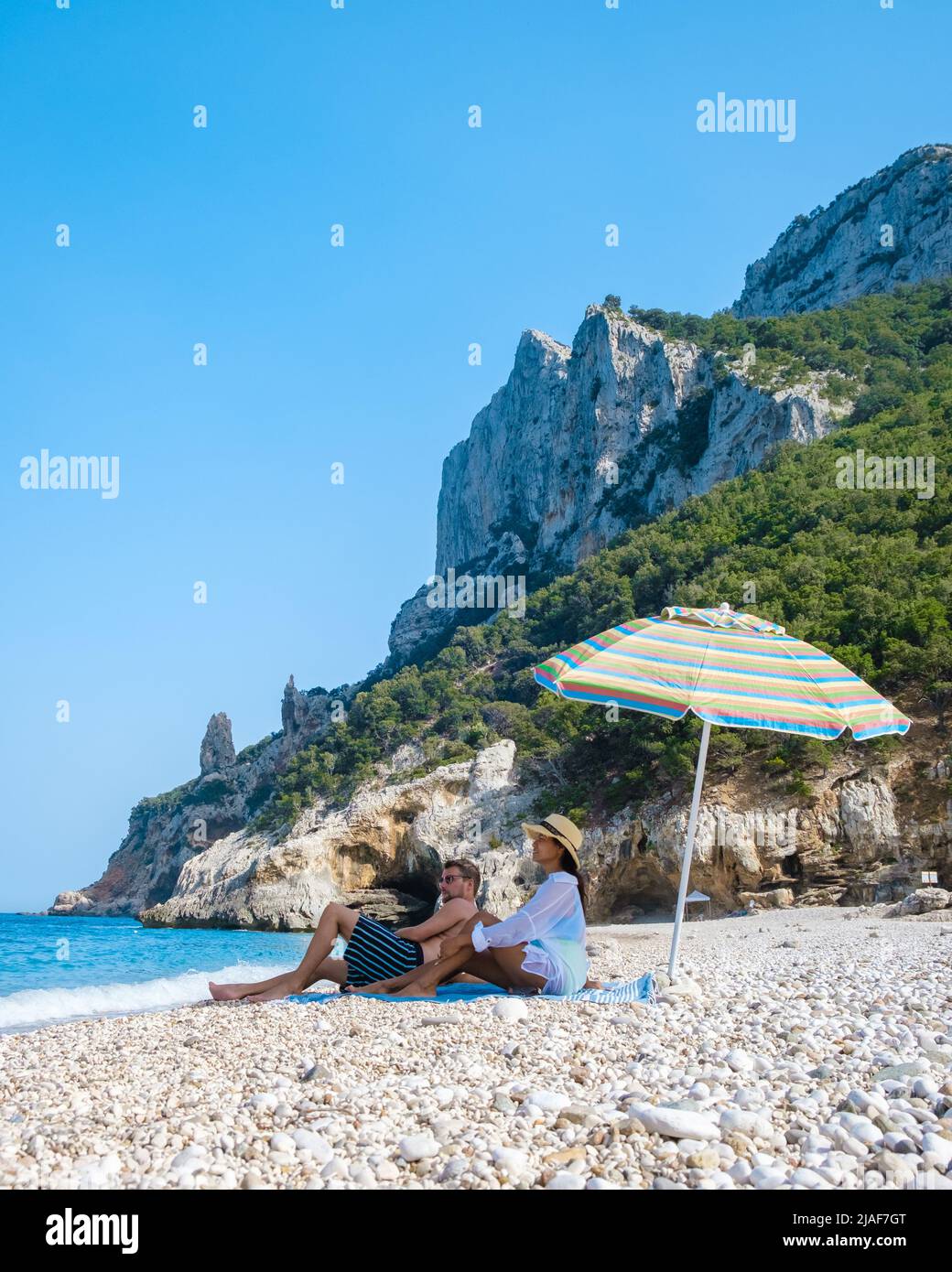 Golfo di Orosei Sardina, Männer und Frauen am Strand Sardinien Italien, junges Paar Urlaub Sardinien Italien, Paar Männer und Frauen spielen im Meer mit kristallklarem blauen Wasser in Italien Stockfoto