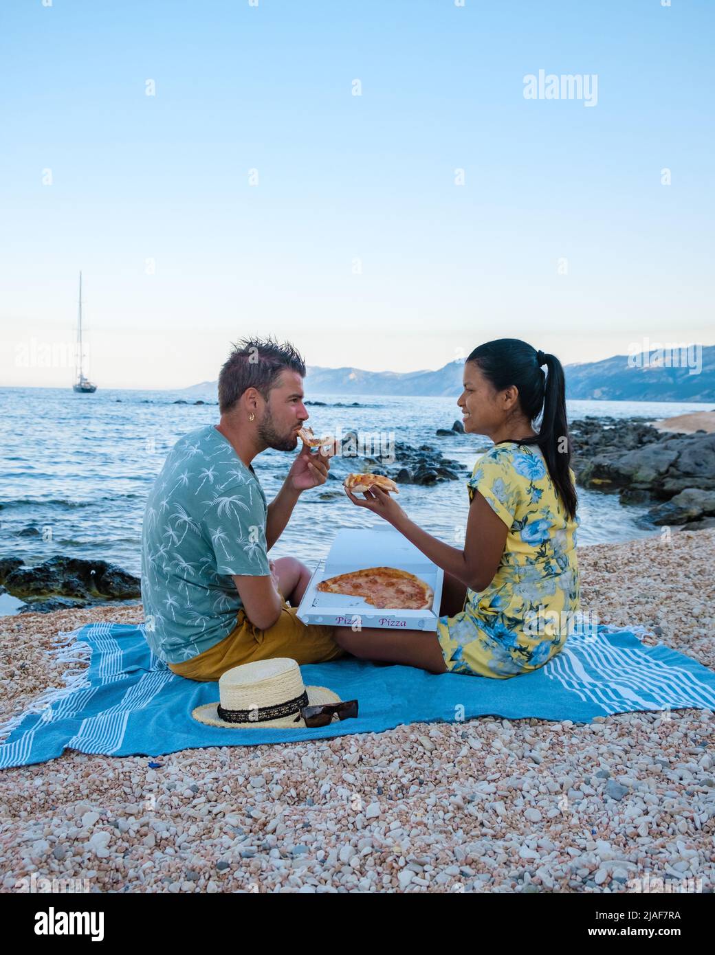 Golfo di Orosei Sardina, Männer und Frauen am Strand Pizza essen, glückliche Männer und Frauen am Strand mit Pizza in Italien. Stockfoto