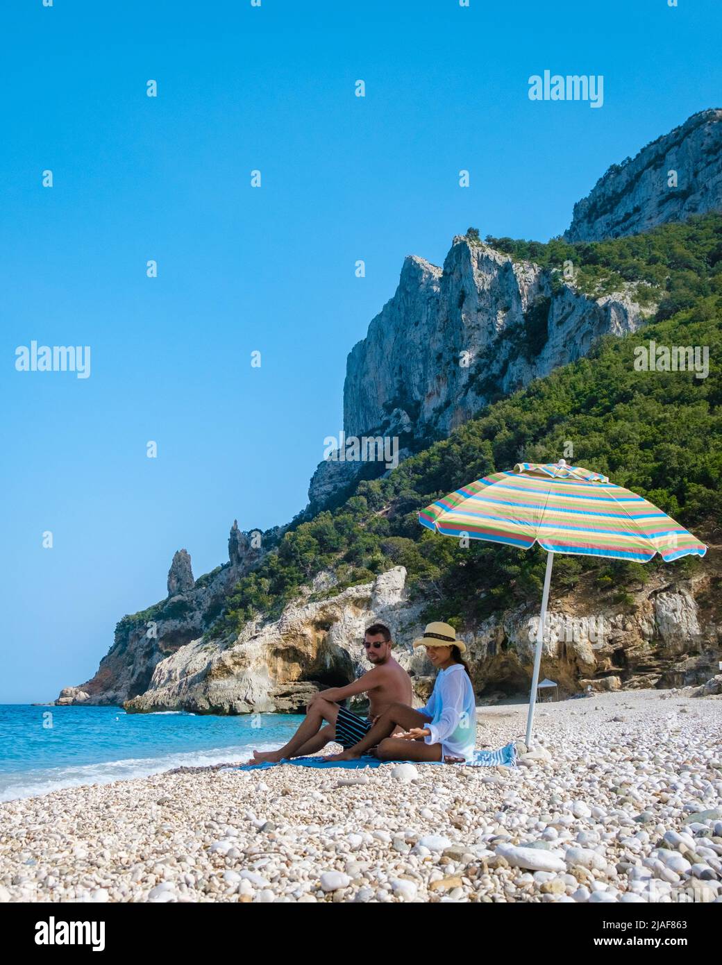 Golfo di Orosei Sardina, Männer und Frauen am Strand Sardinien Italien, junges Paar Urlaub Sardinien Italien, Paar Männer und Frauen spielen im Meer mit kristallklarem blauen Wasser in Italien Stockfoto