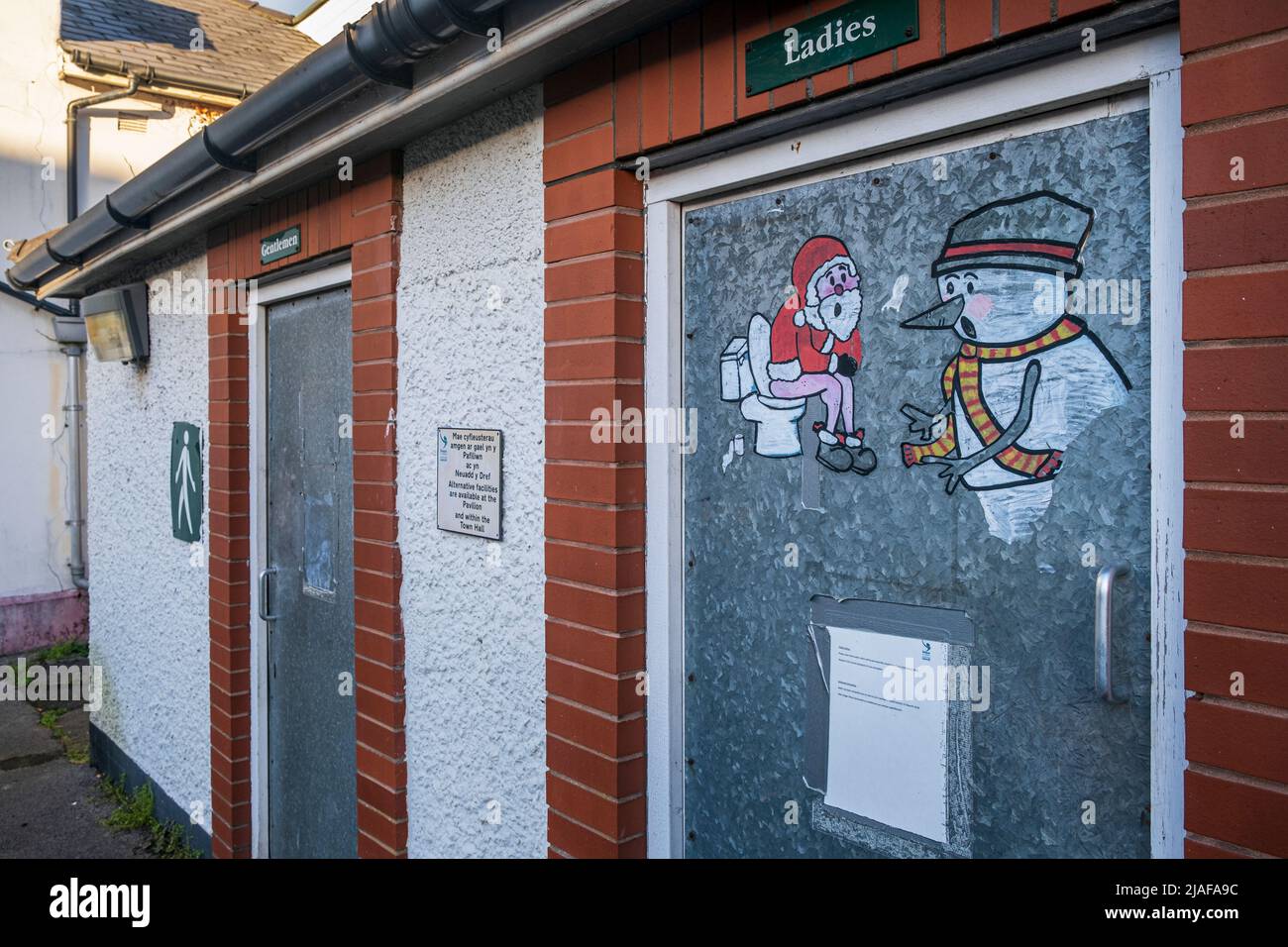 Graffiti-Kunst mit einem Weihnachtsmann und einem Schneemann auf einer öffentlichen Toilette in Caerleon, Monmouthshire, Südwales Stockfoto