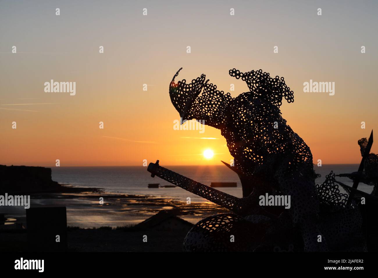 Lebensgroße skulpturale Figur im D-Day 75 Garden in Arromanches-les-Bains, Frankreich bei Sonnenuntergang. Die Installation wurde zuerst von John Everiss für erstellt Stockfoto