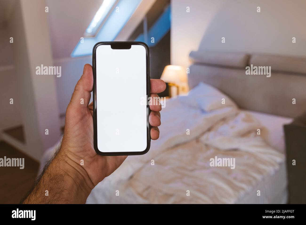 Smartphone-Mockup-Bildschirm, Mann mit Mobiltelefon im Schlafzimmer, selektiver Fokus Stockfoto