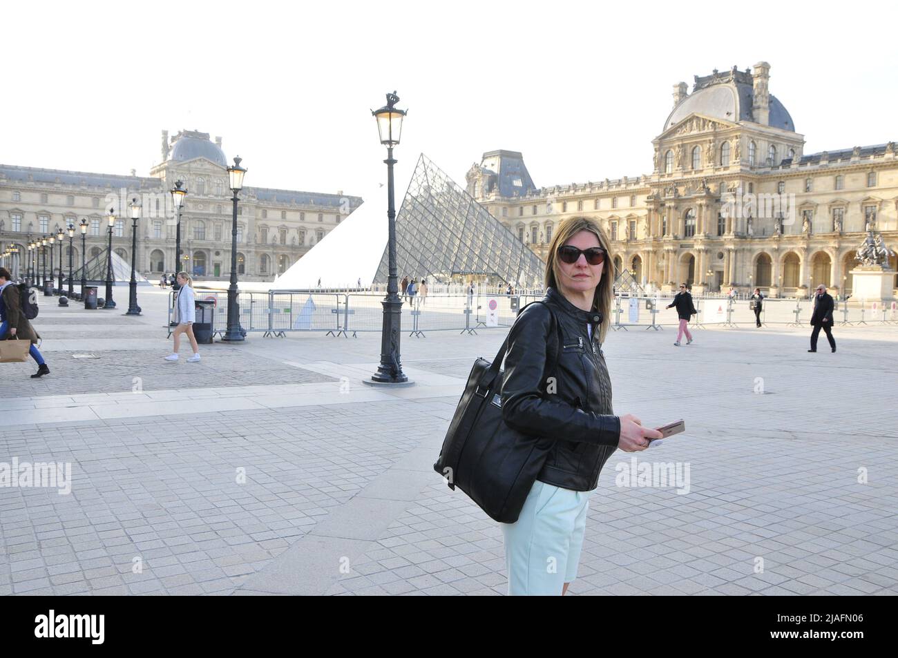 Touristen besuchen die Pyramiden des Louvre-Palasts und Museum. Stockfoto