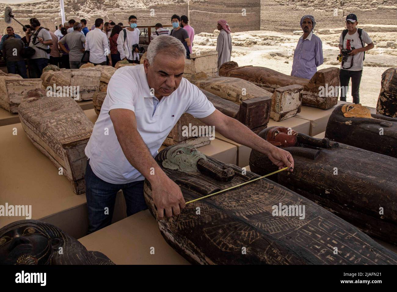 Saqqara, Ägypten. 30.. Mai 2022. Ein Experte misst die Breite eines hölzernen Sarkophags bei einer Medienmöglichkeit, bei der eine neue archäologische Entdeckung von Artefakten aus der späten Zeit des alten Ägypten (ca. 664 v. Chr. - 332 v. Chr.) auf dem heiligen Tierfriedhof in der Nekropole von Saqqara angekündigt wurde. Die Entdeckung umfasst 150 Bronzestatuen altägyptischer Gottheiten und insgesamt 250 hölzerne Sarkophage mit Mumien, die in einem guten Zustand erhalten sind. Quelle: Mahmoud El-Khawas/dpa/Alamy Live News Stockfoto