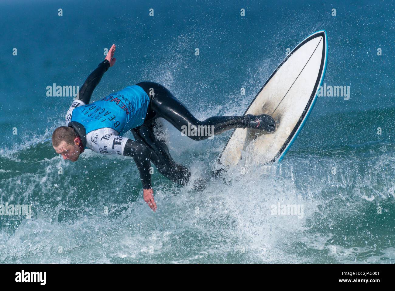 Ein männlicher Surfer, der an einem Surfwettbewerb im britischen Fistral in Newquay in Cornwall teilhat. Stockfoto