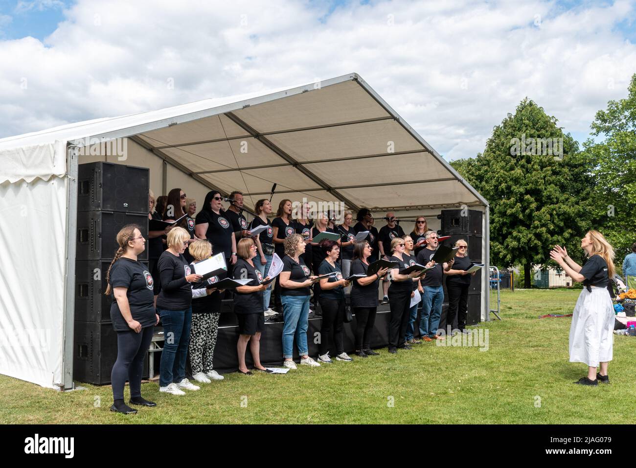 VoxChoir, eine soziale Gesangsgruppe, tritt auf der Bühne bei einem Outdoor-Event in Farnborough, Hampshire, England, Großbritannien, auf Stockfoto