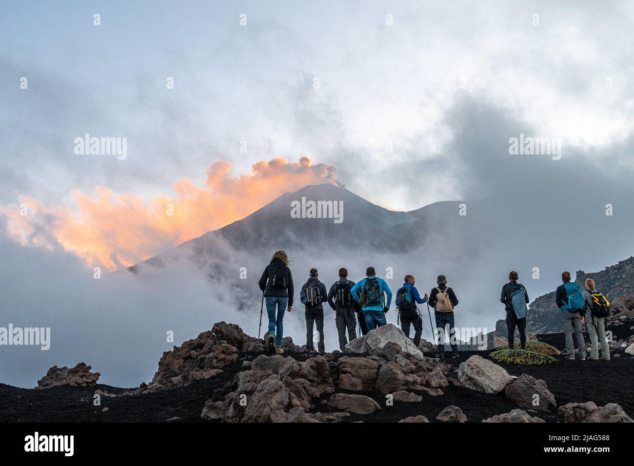 Wanderer, die den Bergrücken der Serra delle Concazze auf dem Ätna besteigen, um den derzeit aktiven Südostkrater des Vulkans zu sehen (Sizilien, Italien) Stockfoto