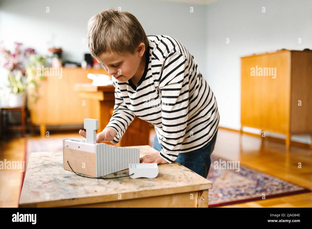 Junge mit Down-Syndrom mit Lernwerkzeug auf dem Tisch zu Hause Stockfoto