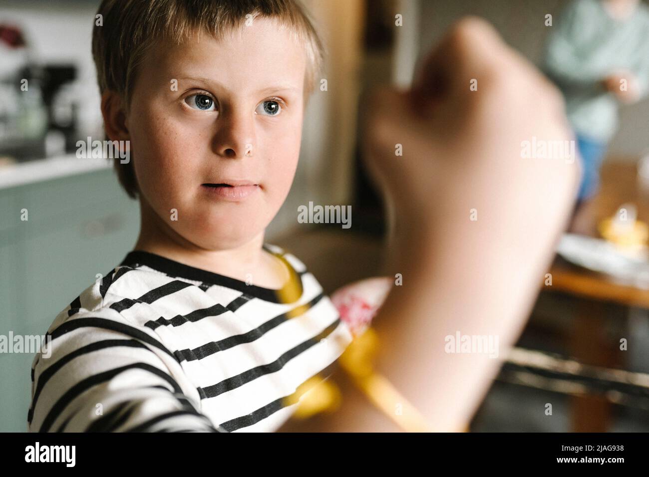 Nachdenklicher Junge mit Down-Syndrom zu Hause Stockfoto