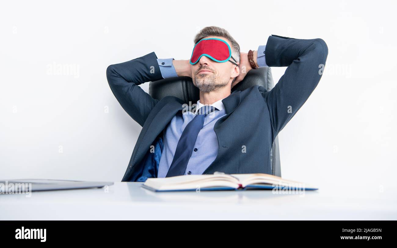 Müde Regisseur entspannen in Schlafmaske am Arbeitsplatz Stockfoto