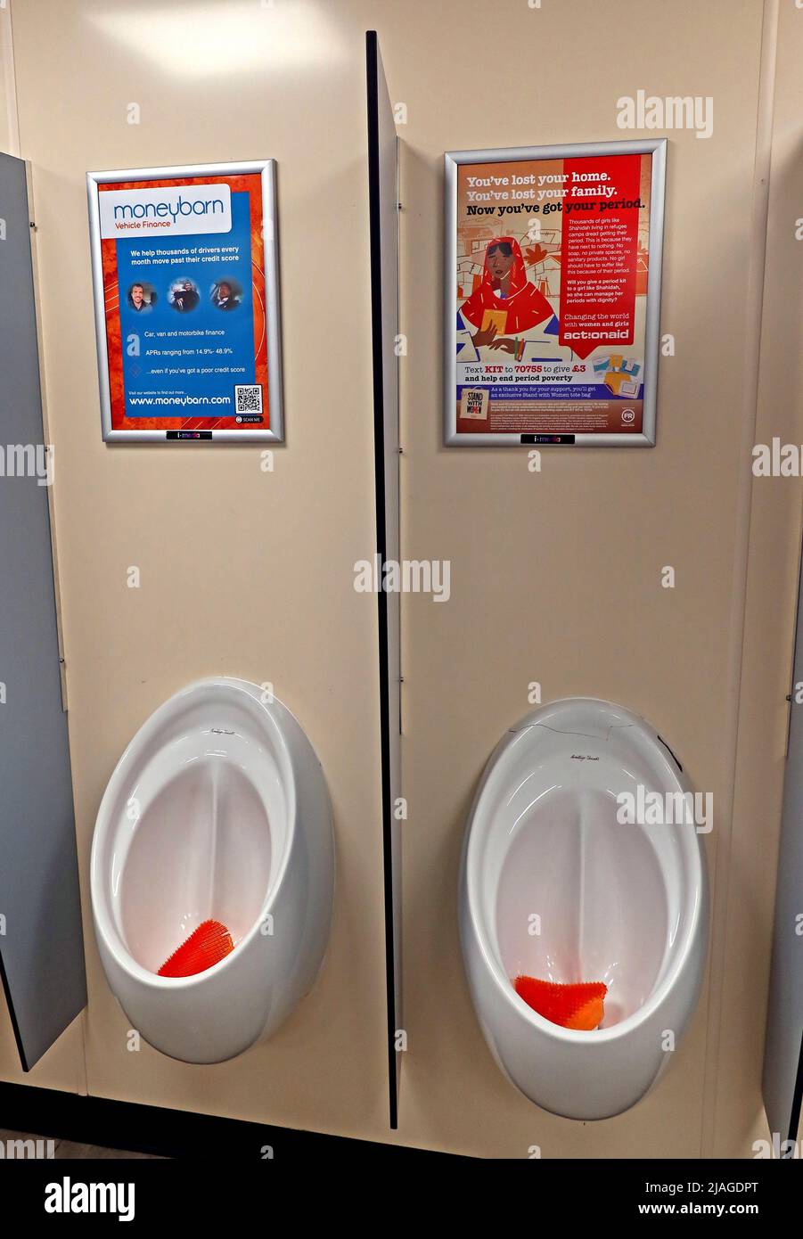 Typische Anzeigen und Werbeaktionen in Autobahntankstellen für Herren-Toiletten, über Urinalen - Moneybarn Car van Finance, ActionAid Phase Poverty Stockfoto