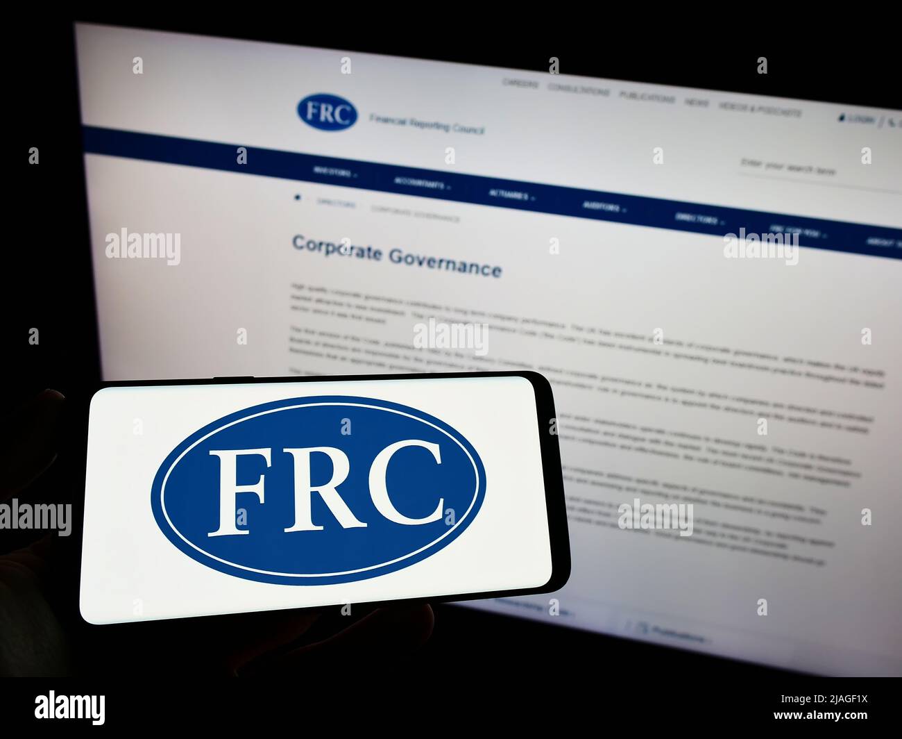 Person, die das Smartphone mit dem Logo des Financial Reporting Council (FRC) auf dem Bildschirm vor der Website hält. Konzentrieren Sie sich auf die Telefonanzeige. Stockfoto