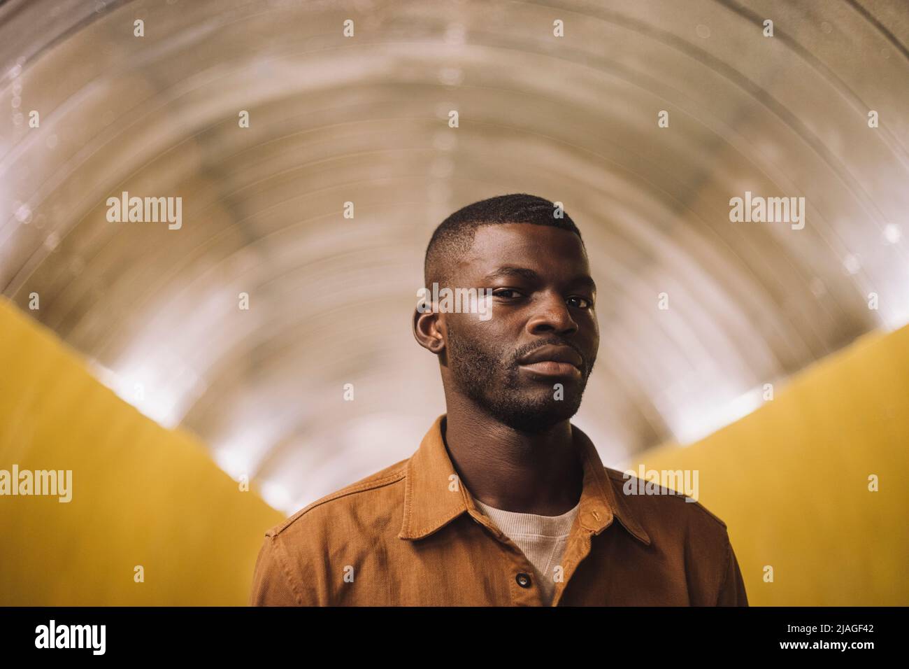 Porträt eines jungen Mannes, der im U-Bahn-Tunnel steht Stockfoto