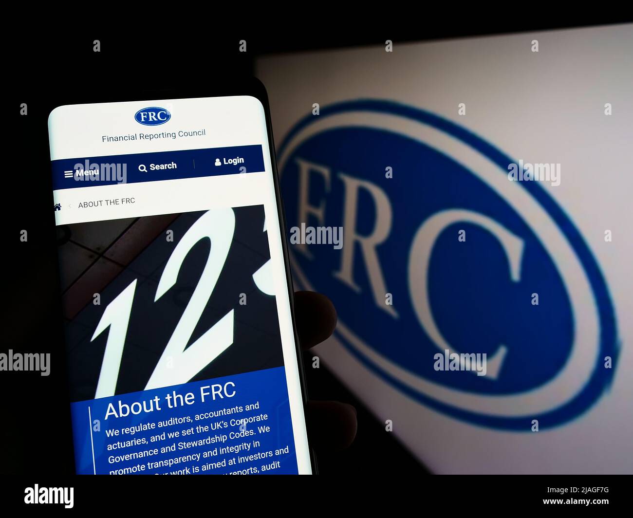 Person, die Mobiltelefon mit der Website des Financial Reporting Council (FRC) auf dem Bildschirm vor dem Logo hält. Konzentrieren Sie sich auf die Mitte des Telefondisplays. Stockfoto