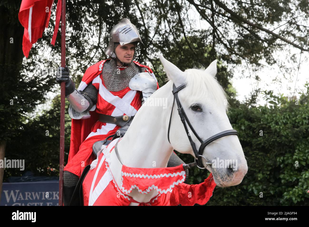 Ritter in glänzender Rüstung auf weißem Pferd zurück in Warwick Castle, Warwickshire, England, Großbritannien, 2022 Stockfoto