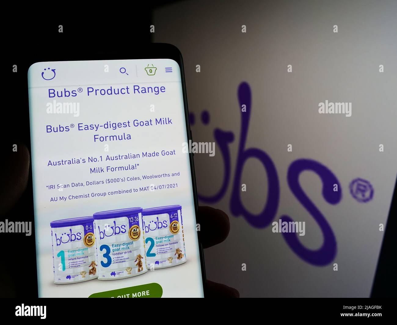 Person mit Mobiltelefon und Webseite des Säuglingsnahrung-Unternehmens Bubs Australia Limited auf dem Bildschirm mit Logo. Konzentrieren Sie sich auf die Mitte des Telefondisplays. Stockfoto
